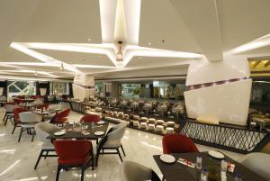 um restaurante com mesas e cadeiras e um bar em The Byke Suraj Plaza Pure Veg, Thane em Thane