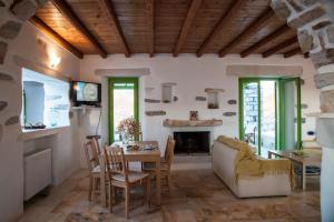 a living room with a table and a fireplace at Villa Aeolos with 2 private pools in Sarakíniko