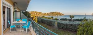 a balcony with a table and chairs and the ocean at Boutique Apartment Volos in Volos
