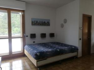 1 dormitorio con 1 cama en una habitación con ventana en La Terrazza, en Vaglia
