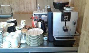 a coffee maker on a counter with plates and cups at Hotelski in Verbier +32 photos