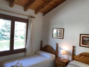 een slaapkamer met 2 bedden en een raam bij Casa - Top Llívia in Llivia