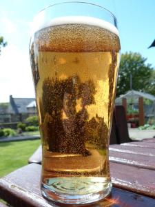 a glass of beer sitting on top of a wooden table at Nethercliffe Hotel in Wick