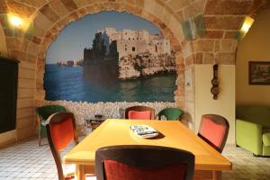 einen Tisch und Stühle in einem Zimmer mit Wandbild in der Unterkunft Mulberry House in Polignano a Mare