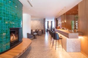 a lobby with a fireplace and a bar at Faloria Mountain Spa Resort in Cortina dʼAmpezzo