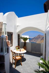 a patio with a table and chairs on a building at Blue Angel Villa in Fira