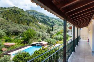 een balkon met uitzicht op een zwembad en de bergen bij Apart Hotel Blumarin in Agios Gordios