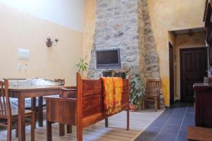 uma sala de estar com televisão numa parede de pedra em Hospedería El Pico del Fraile em Cobreros