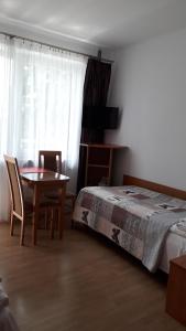 ブスコ・ズドロイにあるPokoje gościnne Busko-Zdrójのベッドルーム1室(ベッド1台、テーブル、椅子付)