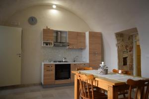 a kitchen with a table with chairs and a counter top at Dovì Casa Vacanze in Carovigno