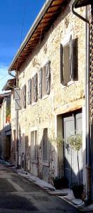 an old stone building with windows on a street at A L’Abri Du Loup in Roquefort-sur-Garonne
