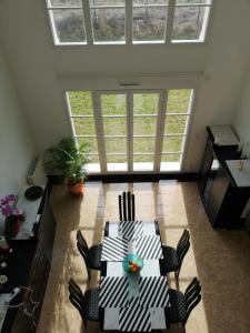 - une salle à manger avec une table, des chaises et des fenêtres dans l'établissement bienvenus chez Éric à Montévrain, à Montévrain
