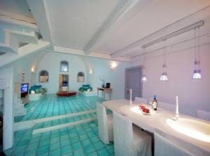 a large room with a tub and a living room at Blue Angel Villa in Fira
