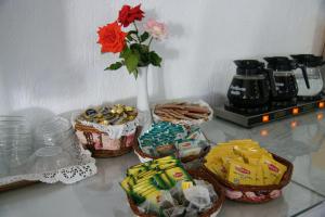 a table with three baskets of cookies and a vase with a flower at Afroditi in Panormos Skopelos