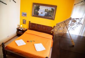 a bedroom with an orange bed with two towels on it at B&B Il Girasole in Balestrate