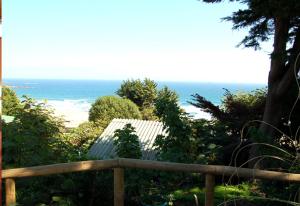 a wooden fence with a view of the ocean at Cabañas Hermansen in Maitencillo