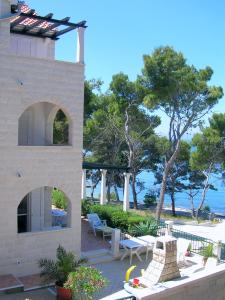 a building with a patio with a view of the ocean at Apartments Villa La Riva - Seafront accommodation in Sutivan