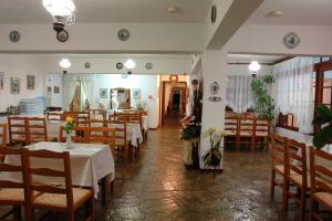 a restaurant with wooden tables and chairs and a room at Afroditi in Panormos Skopelos