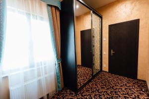 a hallway with a mirror and a door in a room at Khan-Chinar Hotel in Dnipro