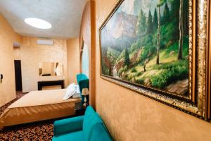 een hotelkamer met een schilderij aan de muur bij Khan-Chinar Hotel in Dnipro