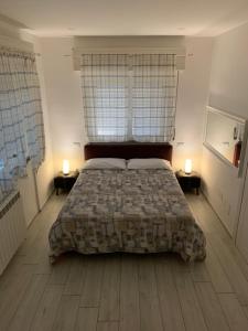 マリネッラ・ディ・サルザーナにあるZena Affittacamereのベッドルーム1室(大型ベッド1台、窓2つ付)