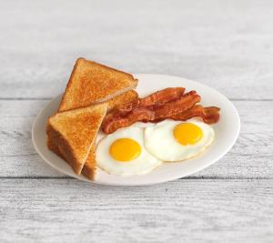 a breakfast of eggs, toast, bacon and toast on a white plate at Best Western Bundaberg City Motor Inn in Bundaberg