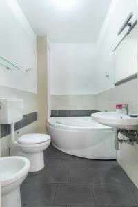 y baño blanco con aseo, bañera y lavamanos. en B&B Porta delle Madonie, en Campofelice di Roccella