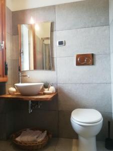 een badkamer met een wastafel, een toilet en een spiegel bij La Terrazza in Vaglia