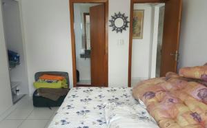 1 dormitorio con 1 cama y puerta con reloj en la pared en Lindo apartamento bairro Aviação, en Praia Grande