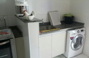 cocina con lavadora y fregadero en Lindo apartamento bairro Aviação, en Praia Grande