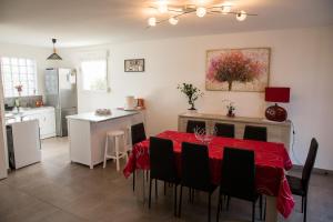 una cocina con una mesa con un mantel rojo. en Gîte Mattaincourt en Mattaincourt