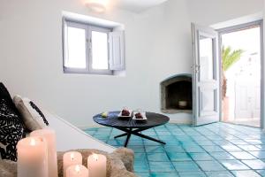 a living room with a table and a fireplace at Blue Angel Villa in Fira