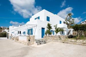 Biały dom z niebieskimi drzwiami na ulicy w obiekcie Marina Blue Ornos w mieście Ornos