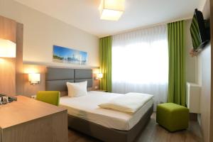a hotel room with a bed and a desk at City-Hotel Kurfürst Balduin in Koblenz +22 photos