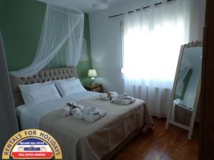 A bed or beds in a room at HELLENIC ESTATE SUITES