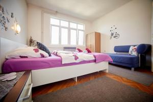 a bedroom with a large bed and a blue couch at Central Tuzla apt - free parking in Tuzla