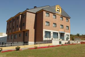 a brick building with a balcony on the side of it at Hostal Tio Pepe II in Bembibre