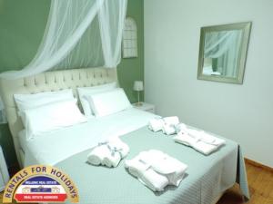 A bed or beds in a room at HELLENIC ESTATE SUITES
