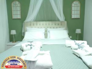 A bed or beds in a room at HELLENIC ESTATE SUITES