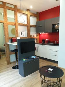 a kitchen with a counter and a table with a tv at Les Appartements de l'Epine in Strasbourg