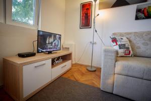 a living room with a tv and a chair at Central Tuzla apt - free parking in Tuzla