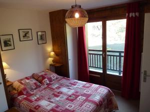 a bedroom with a bed and a balcony at Le Bourjaillet in Notre-Dame-de-Bellecombe