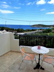 a table and chairs on a balcony with a view of the ocean at Vrokastro Apartments in Istro