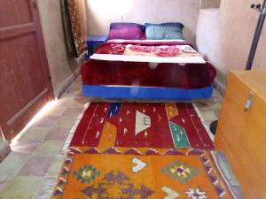 ein Schlafzimmer mit 2 Betten und bunten Teppichen auf dem Boden in der Unterkunft Amerdoul in Icht
