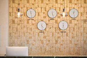 a wall with clocks of different clocks on it at BO Hotel Palazzo in Poreč