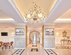 a large hallway with a chandelier in a building at BO Hotel Palazzo in Poreč