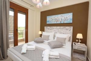 a bedroom with a large bed with white pillows at Saint Paul's Residences in Sani Beach +24 photos