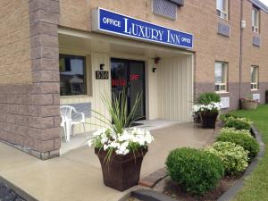 Una entrada principal a un edificio con flores en la acera. en Luxury Inn, en Collingwood