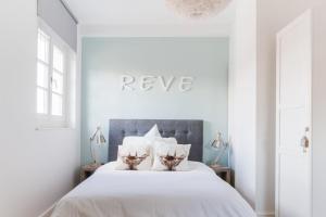 a white bedroom with a white bed with white pillows at Reflets Sur La Lauch appartements in Colmar