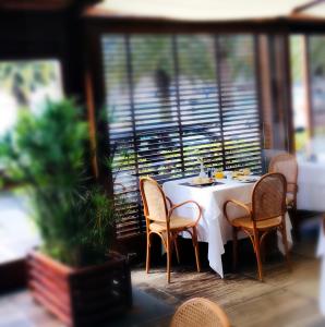 a table with chairs and a white table cloth on a balcony at Hotel Della Baia in Portovenere